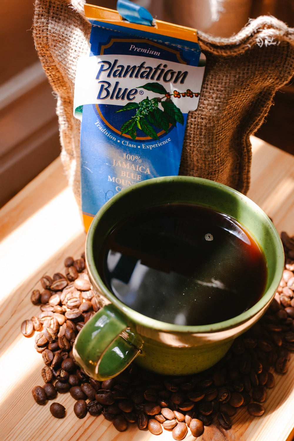 A cup of black coffee in front of a bag of Plantation Blue Jamaica Blue Mountain coffee